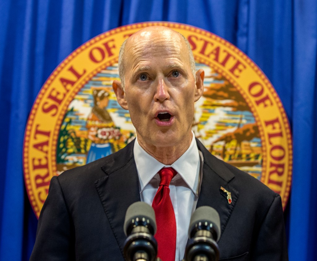 Florida Governor Rick Scott lays out his school safety proposal during a press conference at the Florida Capitol in Tallahassee, Fla., Friday, Feb 23, 2018. Scott proposed banning the sale of firearms to anyone younger than 21 as part of a plan to prevent gun violence.