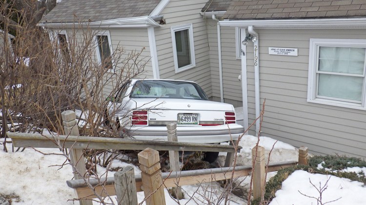 After going airborne and slamming into the home's roof, the car came to rest against the structure's exterior wall.  