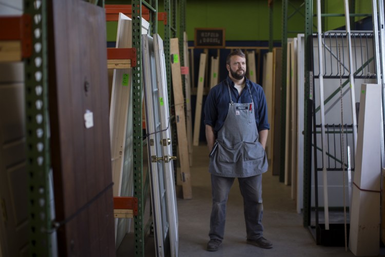 Andrew Smith, near some of the repurposed doors and windows for sale at ReStore in Portland.