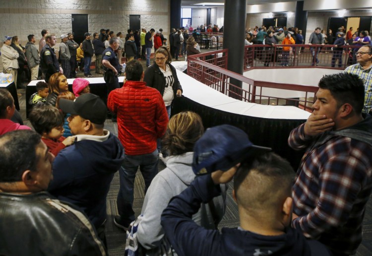 People line up inside the Dalton Convention Center to pick up their children on Wednesday in Dalton, Ga. Students from Dalton High School were evacuated to the convention center after social studies teacher Jesse Randal Davidson barricaded himself in a classroom and fired a handgun, authorities said.