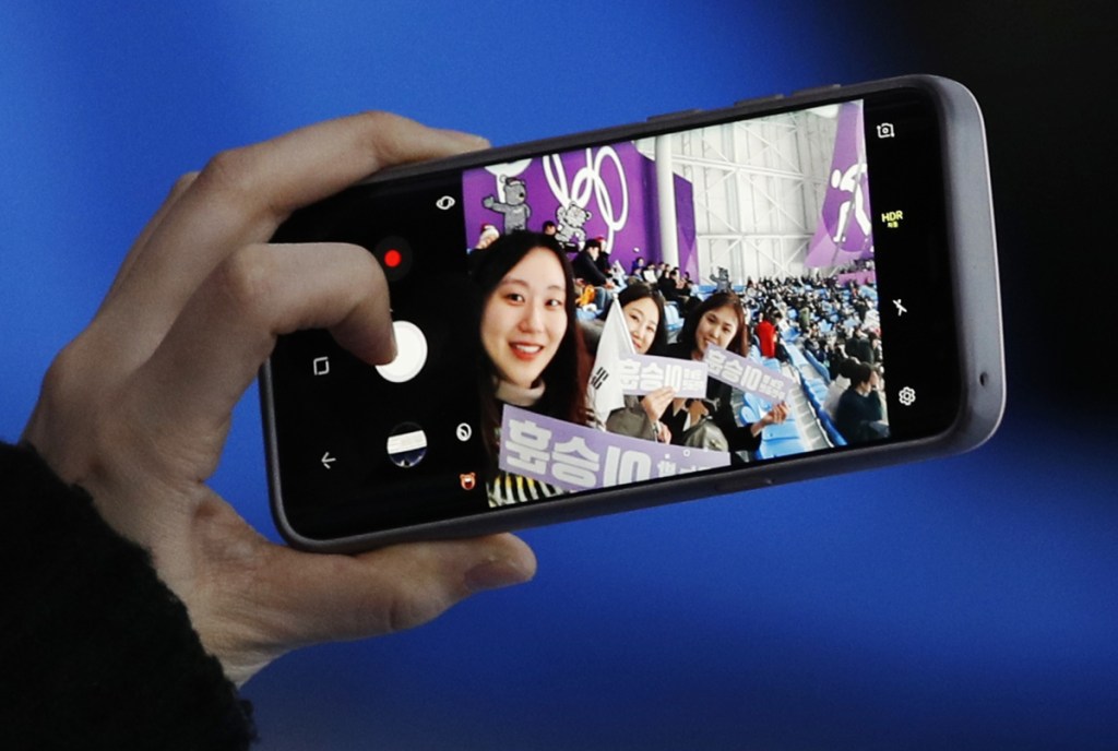 A spectator takes a selfie when waiting for the mass start speedskating races at the Gangneung Oval at the 2018 Winter Olympics in Gangneung, South Korea, Saturday, Feb. 24, 2018. (AP Photo/Vadim Ghirda)