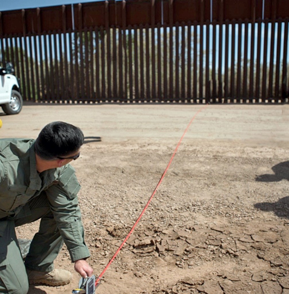 FILE--In this April 14, 2016, file photo provided by U.S. Customs and Border Protection, a Border Patrol agent shows the path of a tunnel that crosses the U.S.-Mexico border near Calexico, Calif. The federal government has started work on a border wall in California to replace a decades-old decaying barrier. SWF Constructors, a tiny Nebraska startup, was awarded the first border wall construction project under President Donald Trump. It is the offshoot of a construction firm that was accused in a government audit of shady billing practices. (U.S. Customs and Border Protection via AP, file)