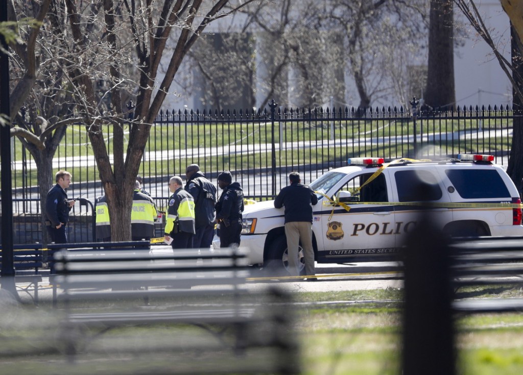 Law enforcement officers gather in front of the White House in Washington on Saturday after a man shot himself outside the building.