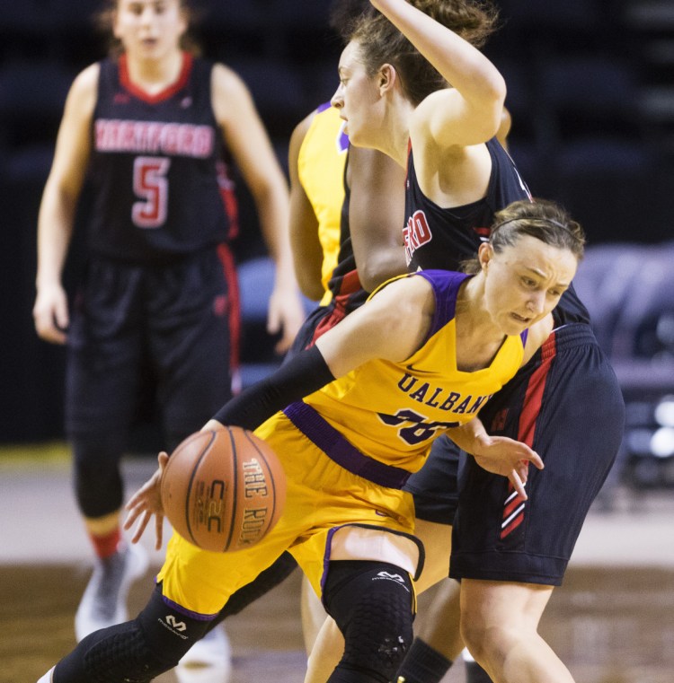 Albany guard Mackenzie Trpcic tries to drive past Hartford's Darby Lee during their America East semifinal Sunday at Cross Insurance Arena. Hartford upset the six-time defending champions, 58-56.