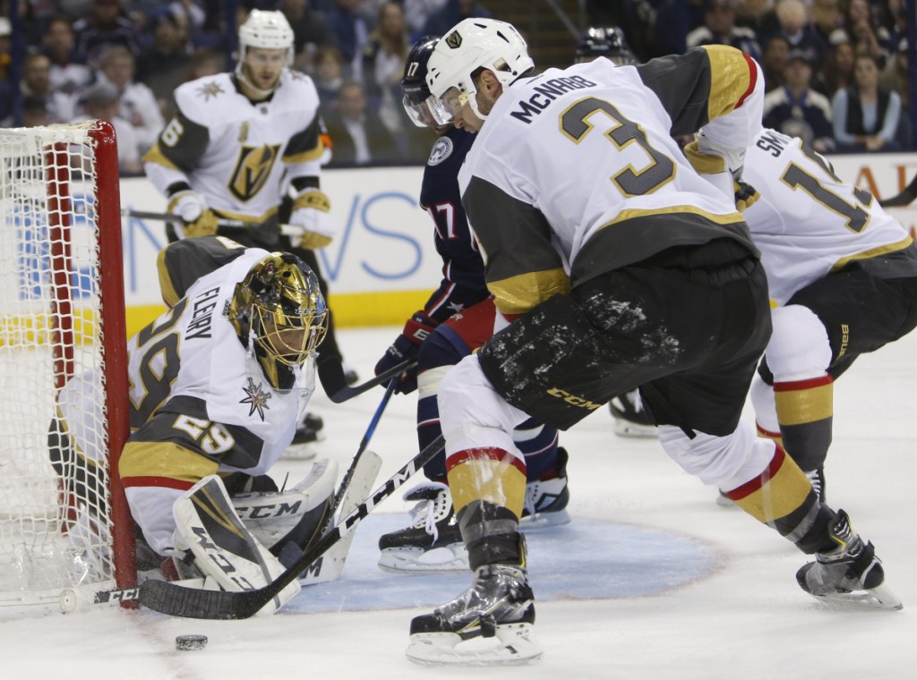 Vegas goalie Marc-Andre Fleury makes a save as Brayden McNabb, right, and Columbus' Brandon Dubinsky look for a rebound during the second period Tuesday night in Columbus, Ohio. Columbus won 4-1.