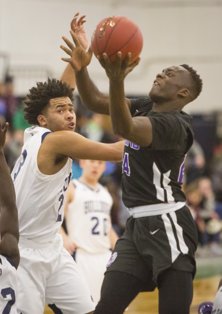PORTLAND, ME - DECEMBER 28: Deering's Ben Onek drives t the basket as Portland's Trev Ballew tries unsuccessfully to defend him during Boys varsity basketball action during the Christmas tournament at the Portland Expo on Thursday, December 28, 2017. (Staff Photo by Carl D. Walsh/Staff Photographer)