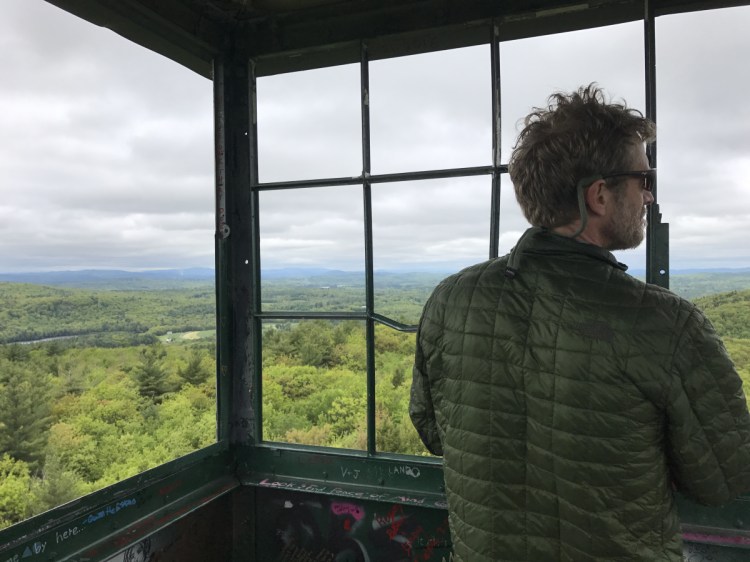 Joel Clement in the fire tower on Mount Pisgah in Winthrop. Clement, who began his career as a forest biologist, became an expert on building resilience to climate change in the Arctic, helping three Alaskan villages in peril from rising seas.