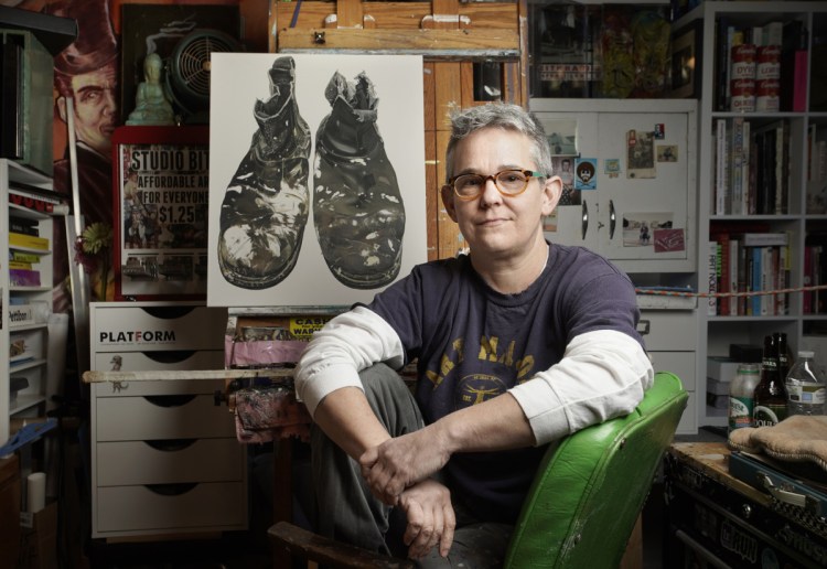 Artist Kelly Jo Shows in her Kennebunk studio. The Center for Maine Contemporary Art is exhibiting her collection of paintings of people's shoes, which she approaches as a portrait process. Behind her is a work in progress of the shoes of local artist Gil Corral.
