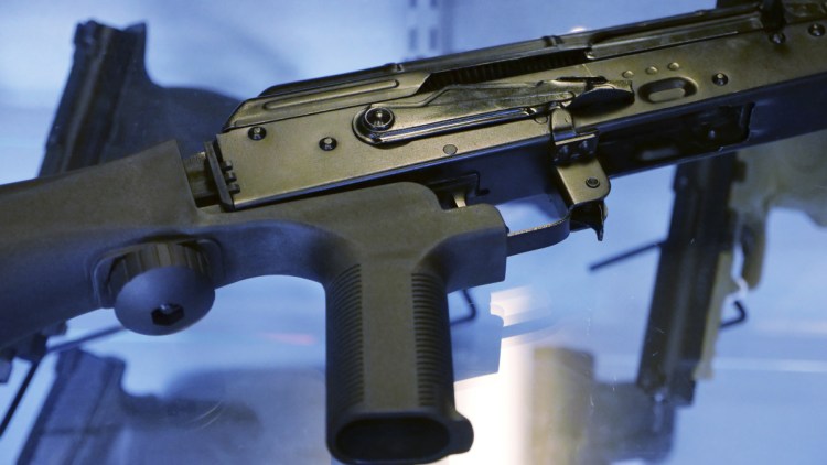 A device called a bump stock is attached to a semi-automatic rifle. The Trump administration is proposing banning bump stocks, which allow guns to mimic fully automatic fire and were used in last year's Las Vegas massacre. The Justice Department's regulation, announced Saturday would classify the device as a machine gun prohibited under federal law.