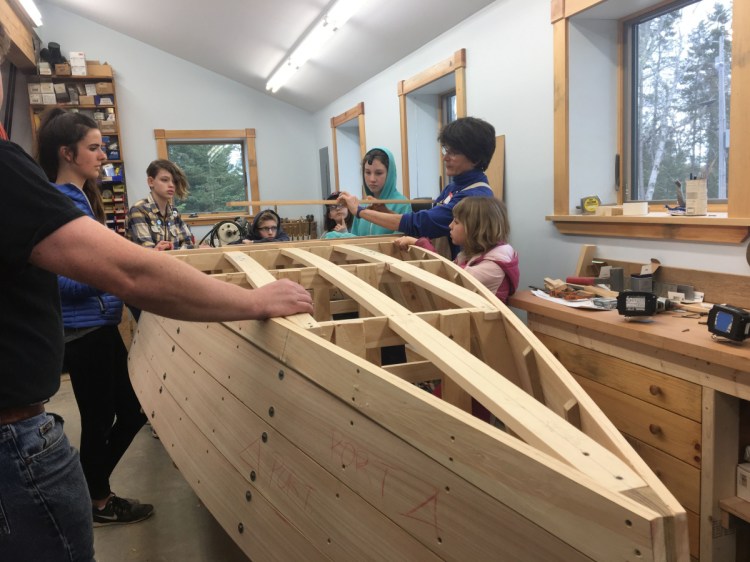 Cundy's Harbor resident Ann Flannery works with the "Harpswell Boat Builders," a free program she created for local kids ages 6 and older. When the rowboat is complete, it will be auctioned off to benefit the Holbrook Community Foundation.