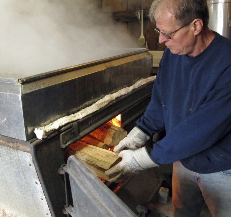 Doug Bragg of Bragg Farm Sugarhouse & Gift Shop in East Montpelier, Vt., loads firewood into an evaporator where he boils maple sap. Maple syrup season started early this year.