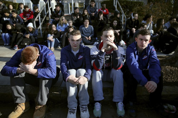 Somerville High School students sit on the sidewalk during a student walkout at the school in Somerville, Mass., on Feb. 28. A nationwide large-scale, coordinated demonstration is planned for this Wednesday.