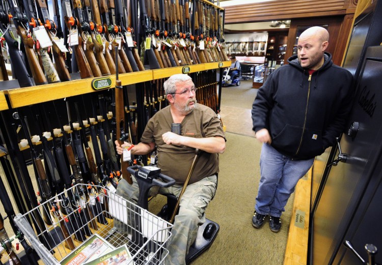 Two men converse near a gun display at the Cabela's store in Dundee, Mich. For many large outdoor stores, hunters account for a big part of their annual bottom line.