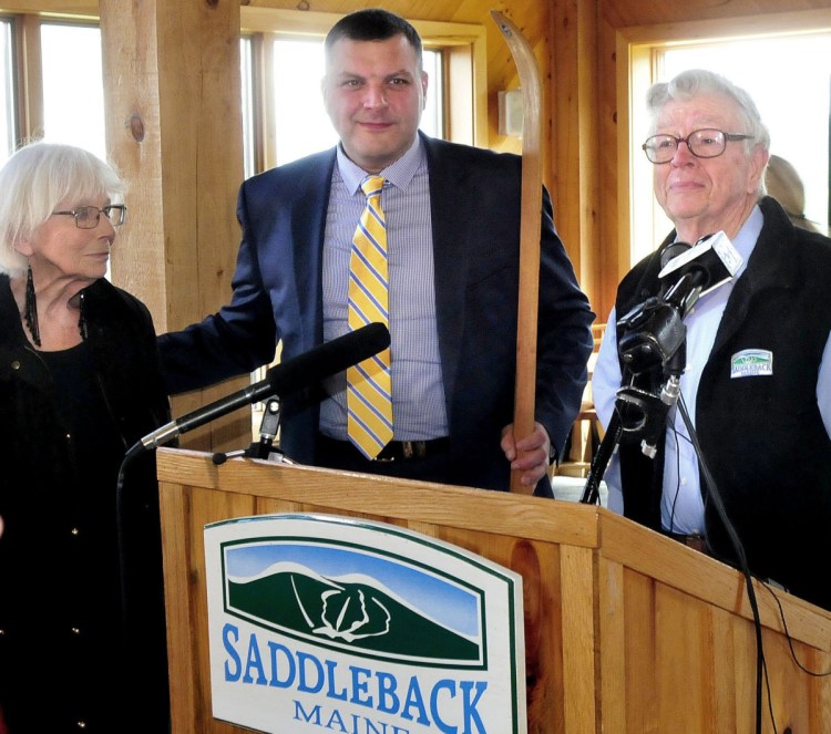 Saddleback owners Irene and Bill Berry pass the traditional wooden ski to Sebastian Monsour, center, chief executive officer of the Majella Group, during the sale announcement at the ski resort last year. The sale has yet to be completed.