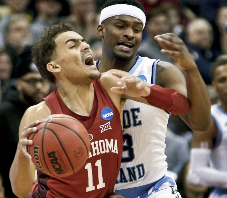 Oklahoma's Trae Young tries to get past Rhode Island defender Stanford Robinson during the first half of Thursday first-round NCAA men's college basketball tournament game in Pittsburgh. Rhode Island advanced with an 83-78 overtime win.