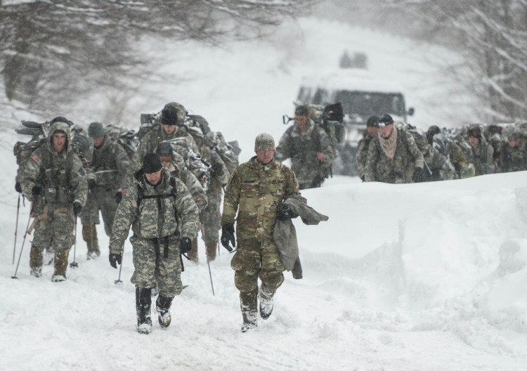 Vermont National Guard soldiers on a training exercise emerge from a closed section on Vermont 108 in Cambridge, Vt., just below Smuggers Notch on Wednesday night after six soldiers were swept about 300 meters by an avalanche.