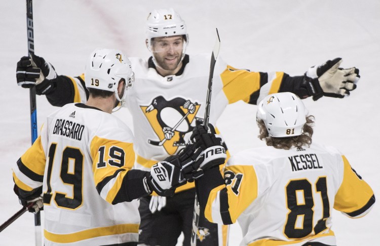 Pittsburgh's Phil Kessel, 81, celebrates with Bryan Rust, 17, and Derick Brassard after scoring against the Canadiens in the first period Thursday night in Montreal.
