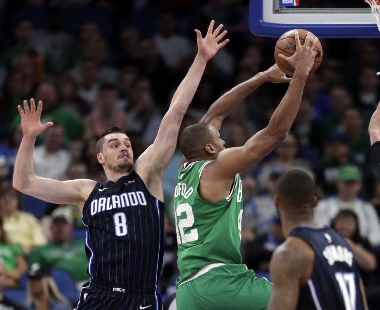 Al Horford of the Boston Celtics goes up for a shot past Mario Hezonja of the Orlando Magic during the first half of the Celtics' 92-83 victory Friday night.