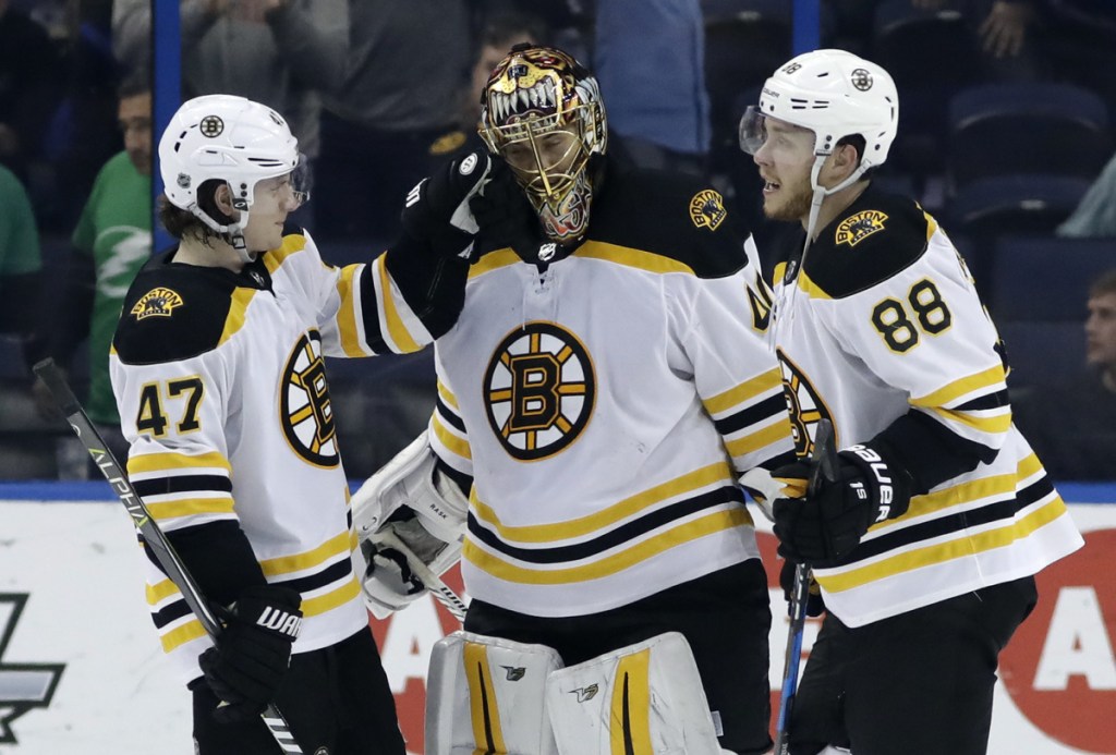 Boston Bruins defenseman Torey Krug, left, and right wing David Pastrnak celebrate with goaltender Tuukka Rask, who made 23 saves in a 3-0 win over the Tampa Bay Lightning on Saturday.