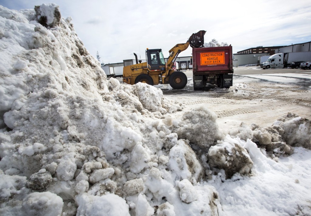 City worker Jeff Clark removes snow from a lot near Commercial Street in Portland last week. Total snowfall is 3 feet above normal this winter, and the two March nor'easters will likely push costs over the city's $1.37 million budget.