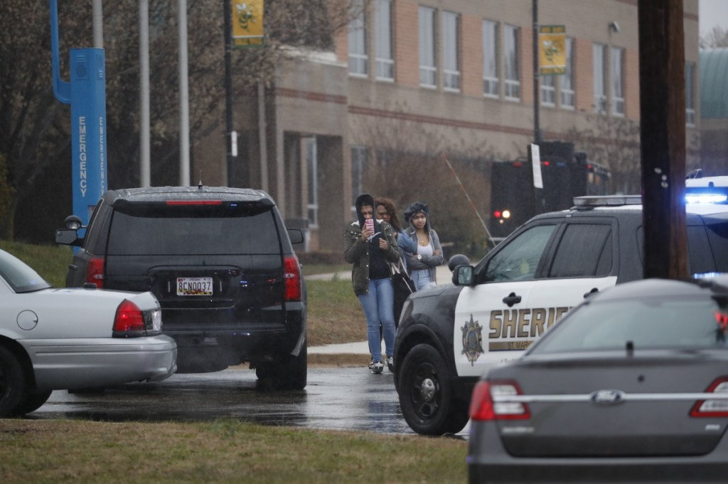 Two students and a mother leave Great Mills High School, the scene of a shooting, on Tuesday morning in Great Mills, Md.