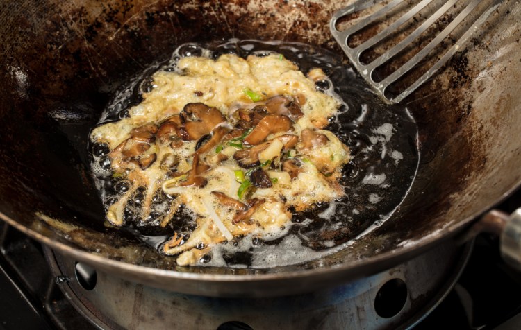 The eggs hold the mushroom and sprout mixture together as a portion begins to fry.