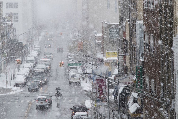 Traffic makes its way along Flushing Avenue in a snow storm Wednesday in the Brooklyn borough of New York.