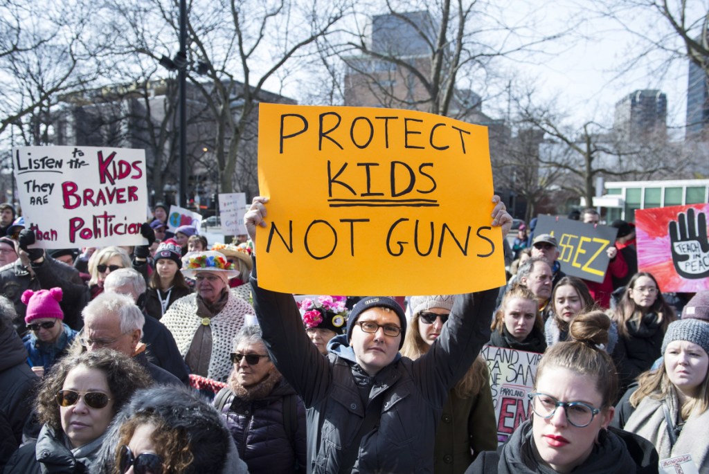 People hold up signs during a March for Our Lives rally for gun control in Montreal, Canada, on Saturday. Thousands of demonstrators around the world marched Saturday.