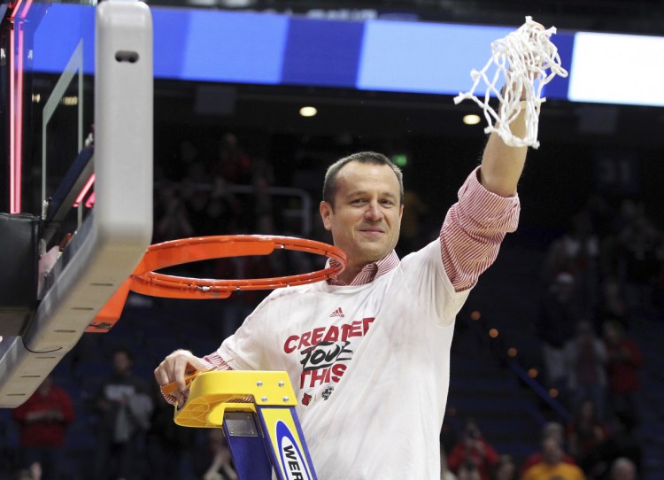 Louisville Coach Jeff Walz holds up the net after his team beat Oregon State 76-43 on Sunday in Lexington, Kentucky, to advance to the Final Four.