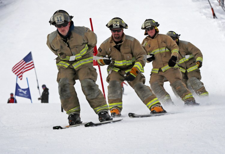 From left, Rumford firefighters Mark Arsenault, Ray Crockett and Brian Lyle and teammates compete in the 28th annual Masters of the Hose ski race at Sunday River ski resort in Newry on Sunday.