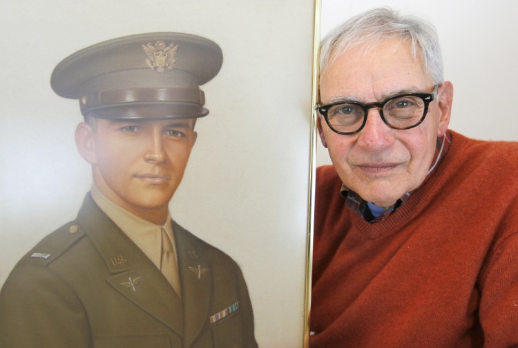 Frank Fazekas Jr. poses with a portrait of his father, Lt. Frank Fazekas, at his home in New Hartford, N.Y. Fazekas was just 6 months old when his father died.