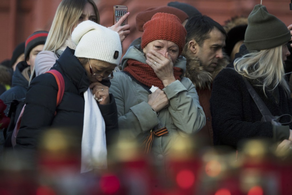 Demonstrators gather Tuesday at a memorial in Moscow to mourn 64 people killed in a fire at a shopping mall in the Siberian city of Kemerovo.