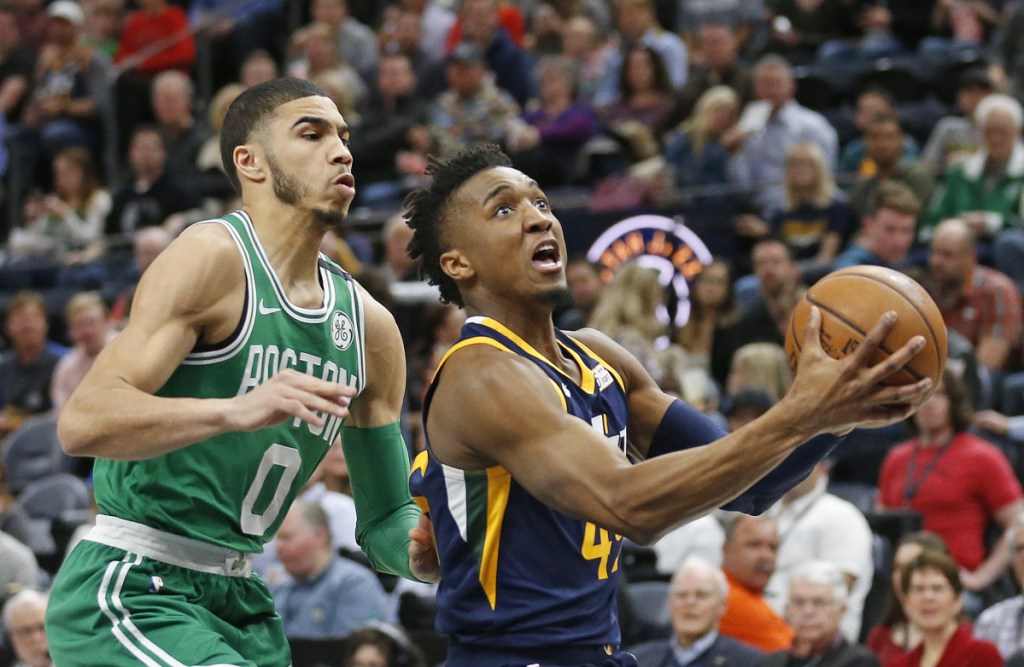 Jazz guard Donovan Mitchell drives to the basket as Celtics forward Jayson Tatum defends.