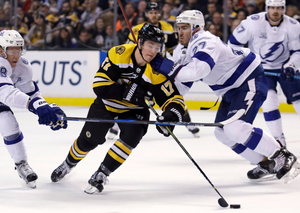 Ryan Donato of the Boston Bruins, center, is checked by defenseman Ryan McDonagh, right, and left wing Ondrej Palat of the Tampa Bay Lightning during the second period of Boston's 4-2 victory Thursday night.