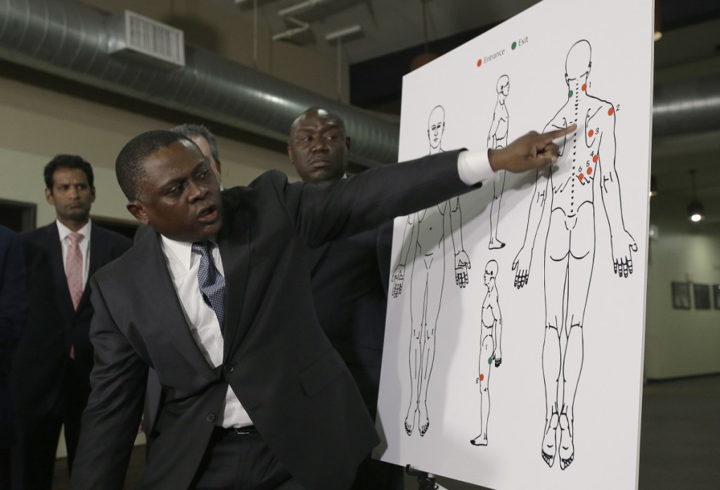 Dr. Bennet Omalu, a pathologist, points to a diagram showing the gunshot wounds he found on the body of police shooting victim Stephon Clark, during a news conference Friday in Sacramento, Calif. Omalu conducted an independent autopsy at the request of Clark's family.