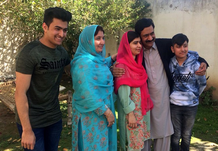 Malala Yousafzai, center, gathers with her family during a visit in March, 2018, to her hometown Mingora for the first time since a Taliban militant shot her there in 2012 for advocating girls' education.