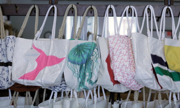 Tote bags made from recycled sails hang in the showroom at Sea Bags in Portland in 2014. It's opening five more stores, three in Maine.