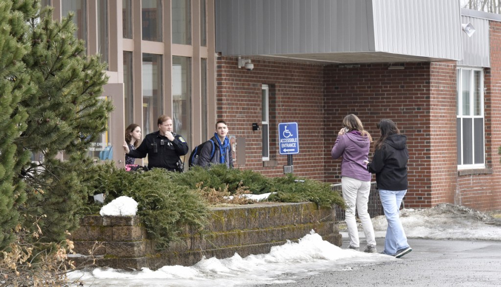 SAD 54 School Resource Officer David Daigneault speaks with parents as students exit the Skowhegan Area High School during a lockout after a threat made Thursday. It was the second threat there this week. Students were allowed to leave the school but no one could enter.