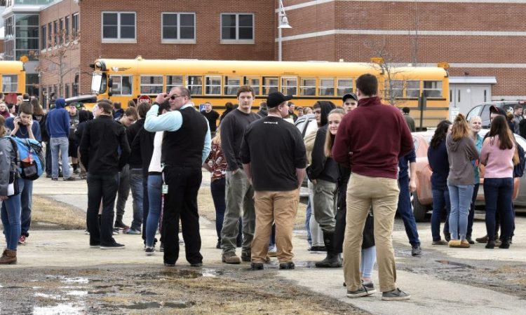 Students and staff stand outside the Mount View school complex in Thorndike as firefighters, police and ambulances responded to reports of a chemical leak on Wednesday that turned out to be pepper spray.
