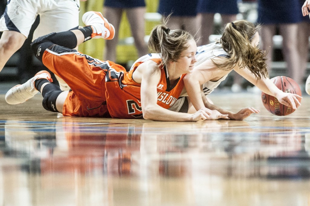 Winslow's Maeghan Bernard, left, battles for a loose ball with Presque Isle's Emily Wheaton during the Class B North championship game Saturday at the Cross Insurance Center in Bangor.