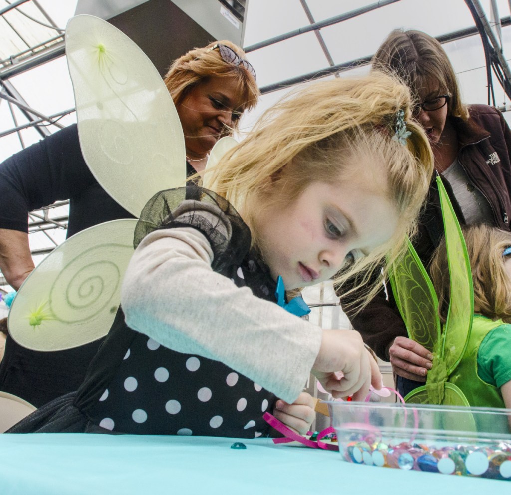 Selha Knapp, 3, of Gardiner, makes a magic wand Saturday during the Annual Fairy Festival at Longfellow's Greenhouses in Manchester.