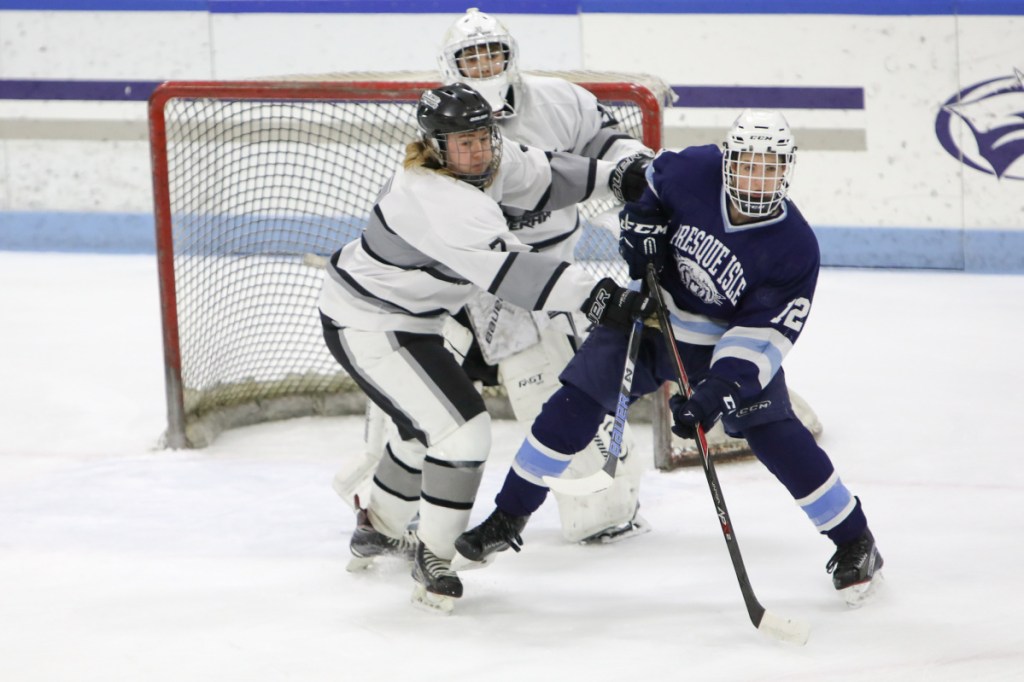 Kennebec's Nicholas West, left, defends goalie Bryce Gunzinger against Presque Isle's Bailey York during a Class B North semifinal game Saturday at Colby College.