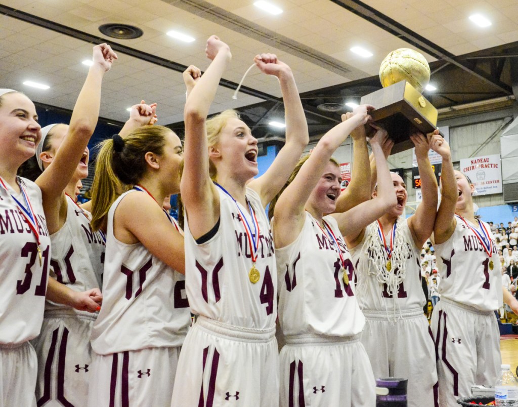 The Monmouth Academy Mustangs celebrate with Gold Ball after beating Houlton to win the Class C state championship game Saturday at the Augusta Civic Center.