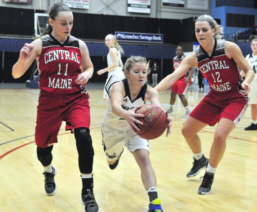 UMA's Emily Billings, center, grabs the ball before it goes out of bounds between Central Maine Community College's Kristina Blais, left, and Brooke Reynolds during a game earlier this season at the Augusta Civic Center.