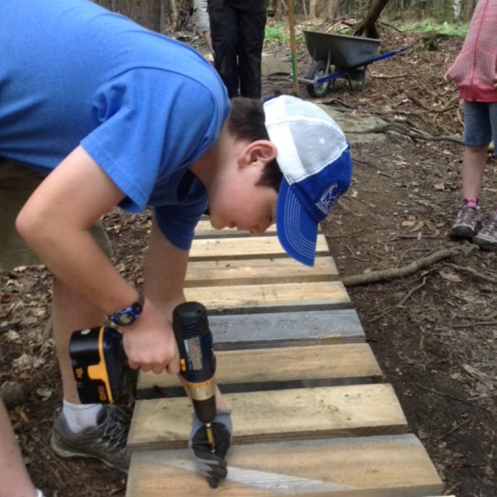 William Jackson, of Waterville, works on a bog bridge in the Pine Ridge trail system for the city of Waterville. It was his Eagle Scout project.