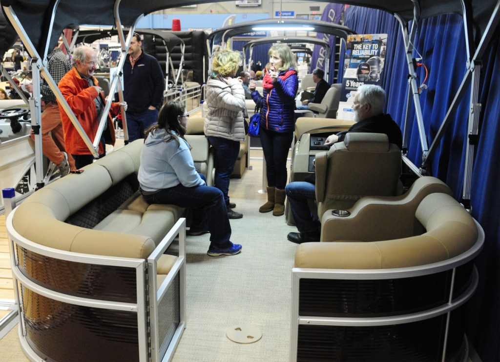 People look over the boats on display Saturday during the Augusta Boat Show in the Paul G. Poulin Auditorium of the Augusta Civic Center.