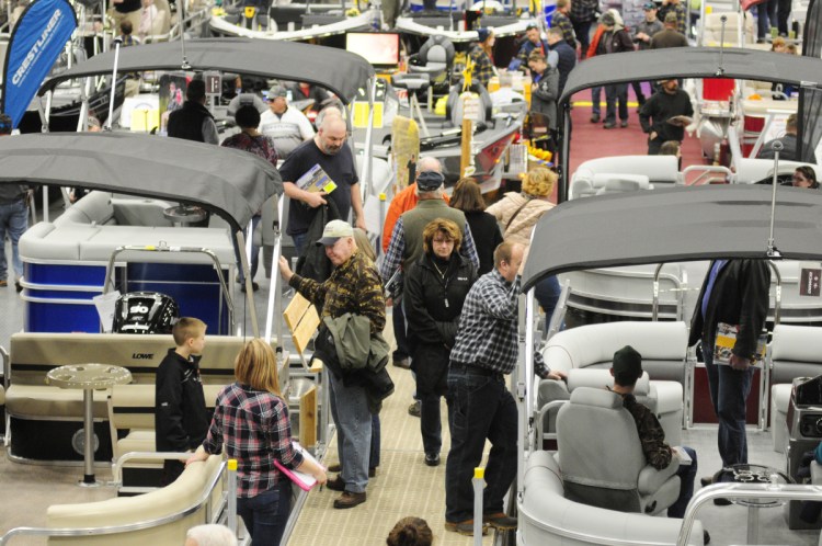 People look over the boats on display Saturday during the Augusta Boat Show in the Paul G. Poulin Auditorium of the Augusta Civic Center.