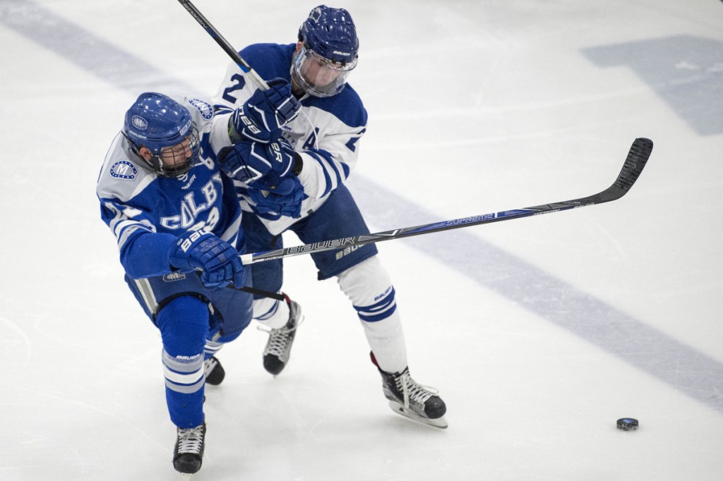 Colby College's Phil Klitirinos, left, collides with University of New England defenseman Ian Rodden during the first period Saturday night at the Harold Alfond Forum in Biddeford.