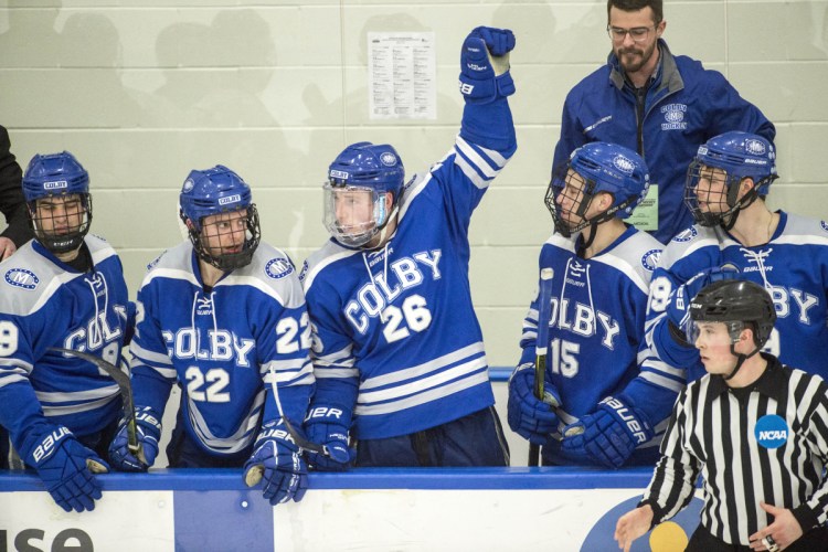 Colby College forward J.P. Schuhlen (26) raises an arm into the air on the Mules’ bench during the final seconds of their NCAA tournament win over the University of New England at the Harold Alfond Forum in Biddeford on Saturday night. 