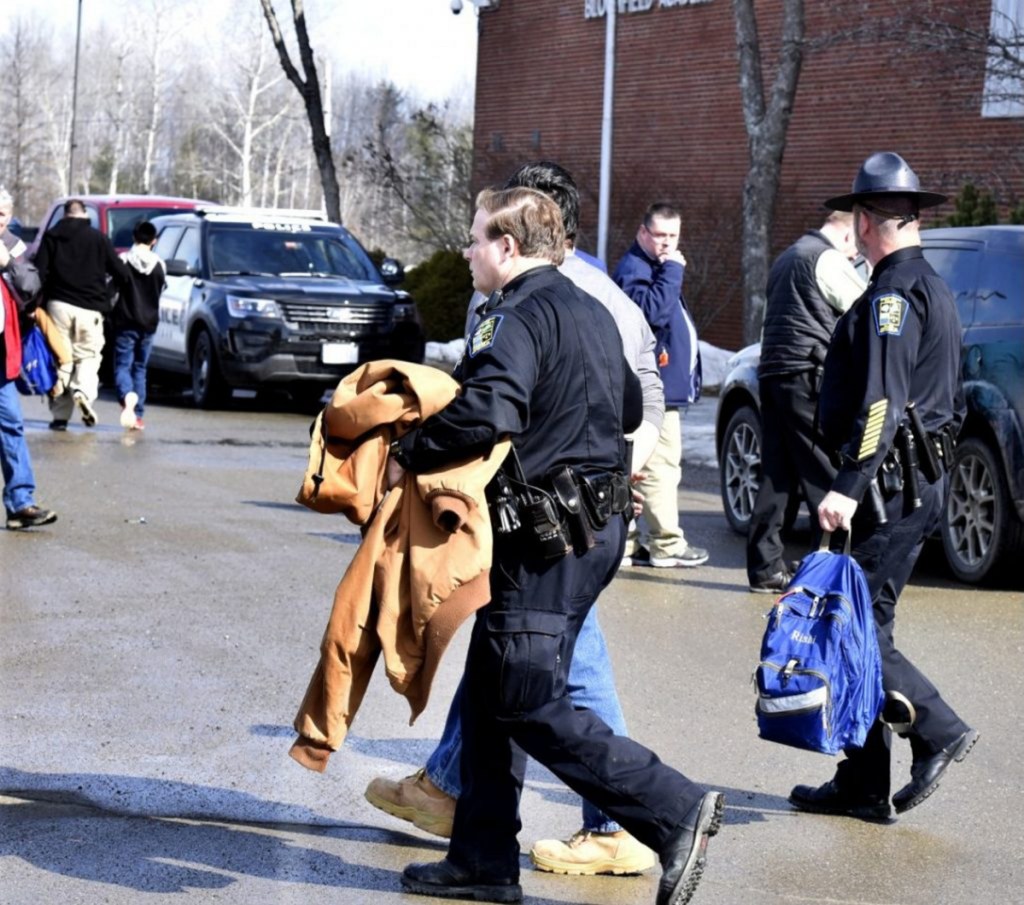 SAD 54 School Resource Officer David Daigneault, center, leads a Skowhegan Area High School student in handcuffs March 1. Another student is placed in a cruiser in the background. The action followed threats to the school that resulted in a lock-out earlier in the day.